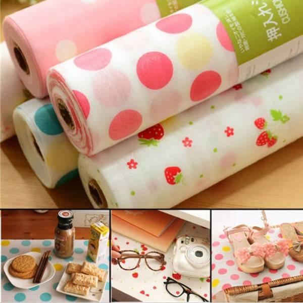 Rolls of multi-purpose drawer and cabinet liner with various colorful patterns such as dots and fruit illustrations. Images also show the liner being used to protect surfaces under a hot plate and to prevent spills on a desk.