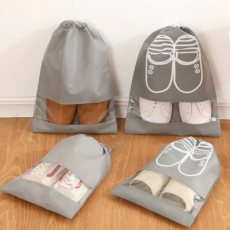 A set of four gray shoe travel cases with transparent windows, showing various shoes inside. Two cases have a hanging option displayed.