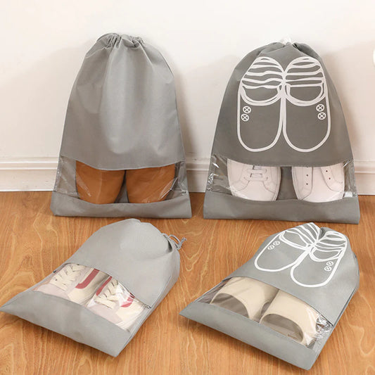 A set of four gray shoe travel cases with transparent windows, showing various shoes inside. Two cases have a hanging option displayed.